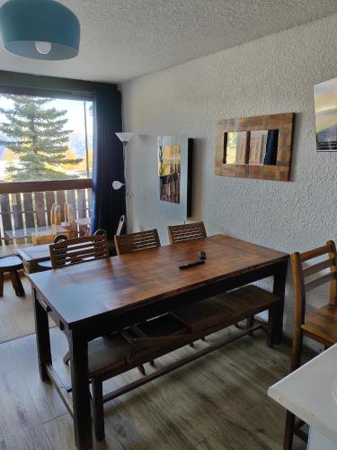 une salle à manger avec une grande table et des chaises en bois dans l'établissement Super Sauze charmant studio en bas des pistes, à Enchastrayes