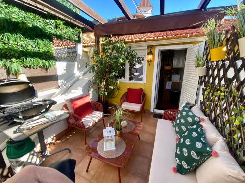un patio con divano, sedie e tavolo di Studios with Mezzanine Rua da Moeda a Lisbona