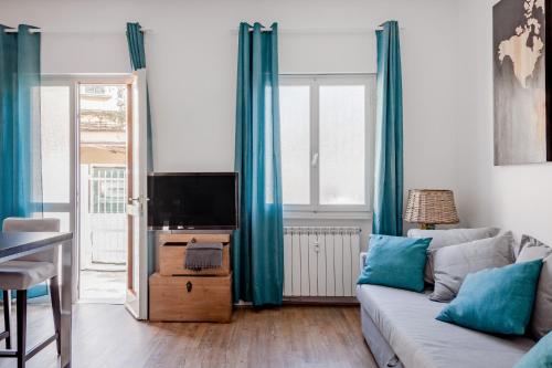 een woonkamer met een bank en een tv bij Open the Classic Wooden Shutters at a Cozy City Nest in Florence