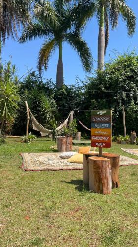 a sign in the grass with palm trees in the background at Estância São Sebastião in Cafelândia