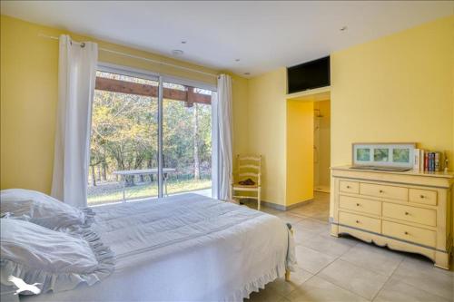 - une chambre avec un lit et une grande fenêtre dans l'établissement Maison moderne et lumineuse, à Castillonnès