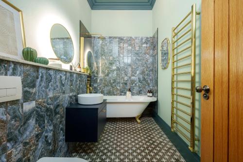 a bathroom with a tub and a sink at The Royal Mint - 2 Bedroom Apartment in Central Bristol by Mint Stays in Bristol