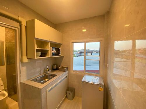 a small bathroom with a sink and a window at S.P.C Apartment by Brodderud in Bangkok