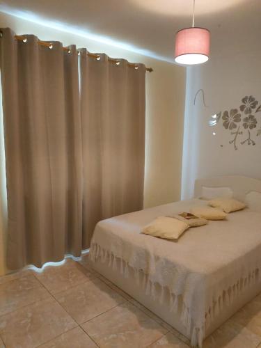 a bedroom with a bed with curtains and a light at Résidence Lennards 3 in Grand Baie