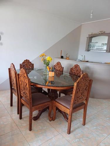 a dining room table and chairs with flowers on it at Résidence Lennards 3 in Grand Baie
