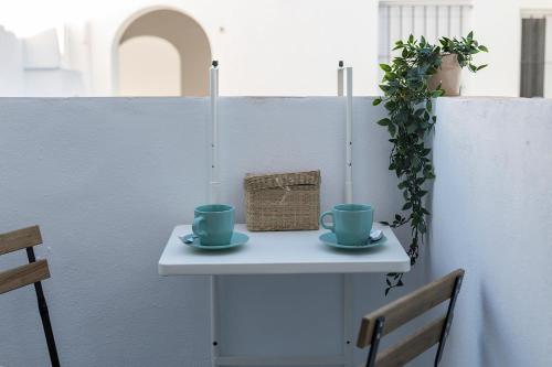 a table with two cups and a basket on it at San Miguel Tranquilo Moderno in Jerez de la Frontera