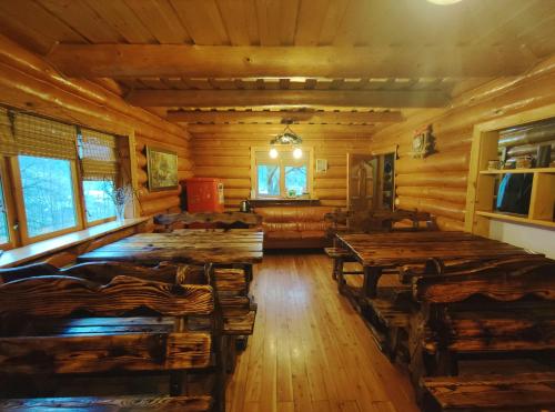 a dining room with wooden tables in a log cabin at Дерев'яний котедж "Казка" in Yaremche
