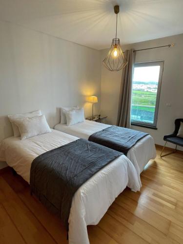Duas camas num quarto com uma janela grande em Penthouse Terrace Apartment em Ponta Delgada