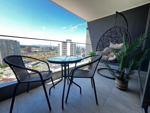 a balcony with a table and chairs and a view of a city at Apartamento Reñaca Live in Viña del Mar
