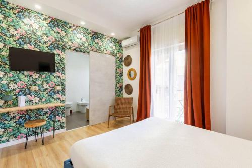 a bedroom with a white bed and a floral wall at Tufo Giallo Rooms in San Giorgio a Cremano