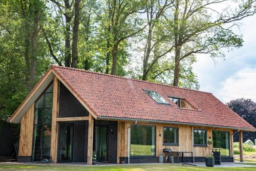 ein Haus mit rotem Dach in der Unterkunft Het Haerman in De Lutte
