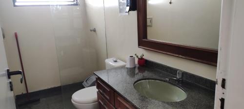 uma casa de banho com um lavatório, um WC e um espelho. em Pousada Easy Floripa em Florianópolis