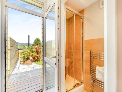 a bathroom with a glass door leading to a balcony at Westhaven, Minehead in Minehead