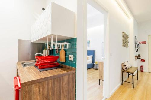 a kitchen with a red chair on a counter at Tufo Giallo Rooms in San Giorgio a Cremano