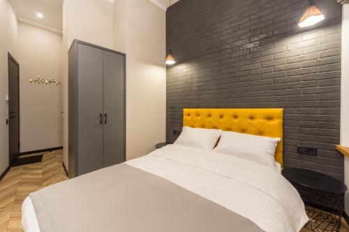 a bedroom with a white bed and a brick wall at DayFlat Apartments Maidan Area in Kyiv