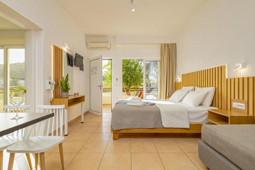 ein Schlafzimmer mit einem Bett und ein Wohnzimmer in der Unterkunft Theos Village Apartments in Kato Daratso