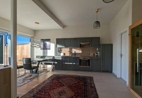 uma cozinha com armários pretos e uma mesa e cadeiras em Luxurious & lovely apartment with infrared cabine em Prüfingberg