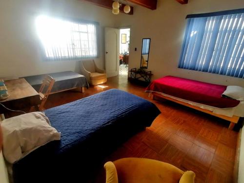 una camera con un grande letto e una coperta rossa di Casa Tewa a San Luis Potosí