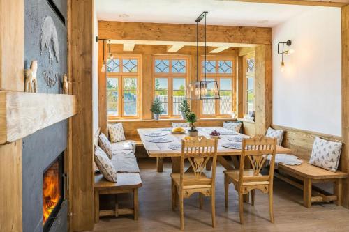 ein Esszimmer mit einem Tisch, Stühlen und einem Kamin in der Unterkunft Rent like home - Willa Zoniówka in Zakopane