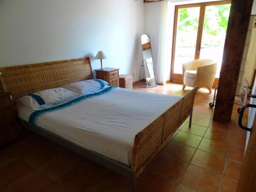 a bedroom with a large bed with a wooden frame at La Chillaudie in Verteillac