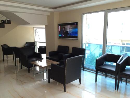アクチャコジャにあるBayraktar Hotelの椅子、テーブル、テレビ付きの待合室