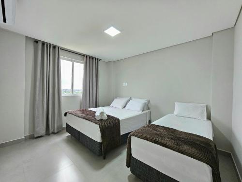 um quarto de hotel com duas camas e uma janela em Apt Novíssimo 3quartos 2vagas garagem prox centro em Foz do Iguaçu