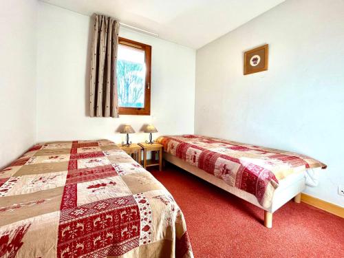 Appartement 3 pièces avec piscine et parking au centre du village - FR-1-505-198 في نوتر دام دو بيلكومبيه: غرفة فندق بها سريران ونافذة