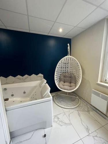 uma casa de banho com uma banheira branca e uma cadeira. em Appartement : Le Portel em Le Portel