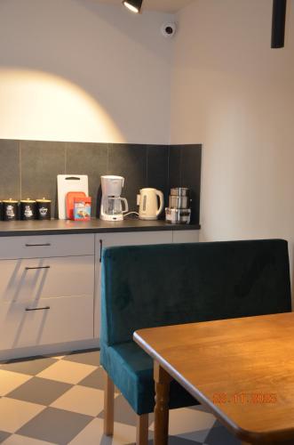 a kitchen with a table and a green chair at Arte Gdańsk in Gdańsk