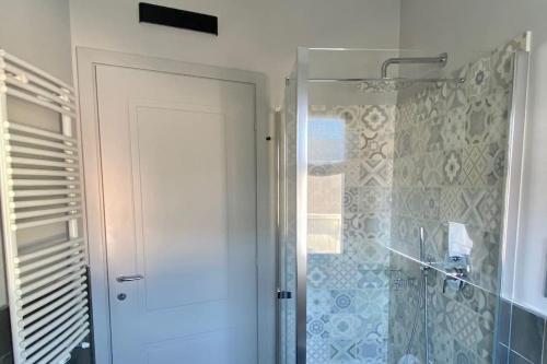 een badkamer met een douche en een glazen deur bij Le Terrazze 18 in Brescia