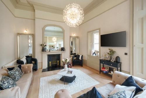 a living room with a couch and a tv at The Sovereign Suite - 2 Bedroom Apartment in Central Bristol by Mint Stays in Bristol
