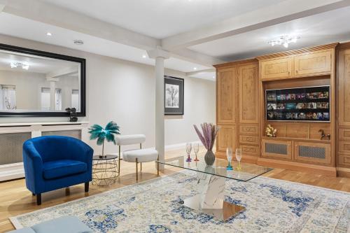 a living room with a blue chair and a glass table at ULTRA MASSIVE House by HYDE PARK in London