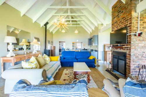 a living room with blue couches and a fireplace at Midlands Lakehouse in Rosetta