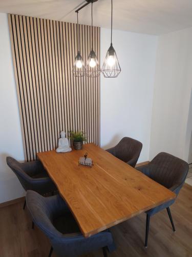 a dining room table with chairs and two lights at Ginkgo(T)raum in Dresden