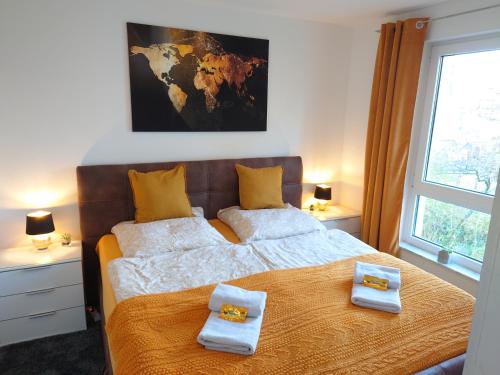 une chambre avec un grand lit avec deux serviettes dessus dans l'établissement GinkgoTraum, à Dresde