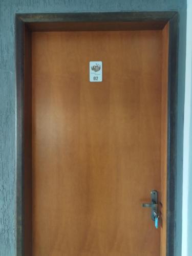 eine Holztür mit einem Schild drauf in der Unterkunft Hostel in Capitólio