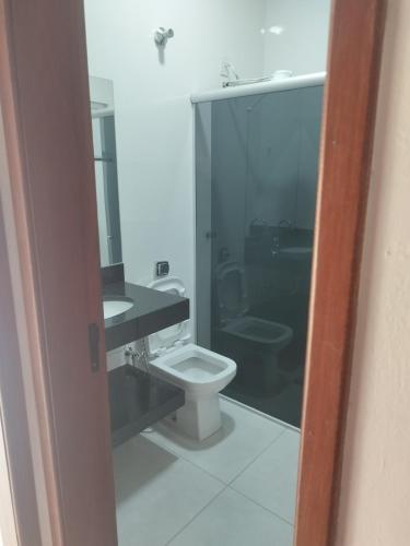 a bathroom with a toilet and a sink at Hostel in Capitólio