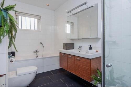 a bathroom with a toilet and a sink and a tub at Mooie kamer uitzicht op de ijssel/ Nice room with beautiful view of the Ijssel river in Wijhe