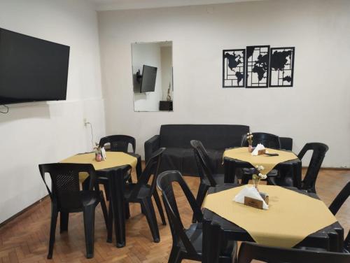 a dining room with tables and chairs and a couch at Houselyon in Mendoza