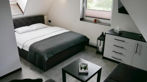 a small bedroom with a bed and a table at BLACK & WHITE HOUSES in Niedzica