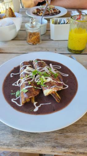a plate of food on a wooden table at Sueños Tulum in Tulum