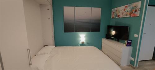 a bedroom with a bed and a flat screen tv at L'alloggetto sul Corso in Cuneo
