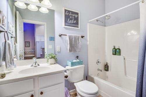 a white bathroom with a sink and a toilet at Camdenton Condo with Patio, Pool and Lake Access! in Camdenton