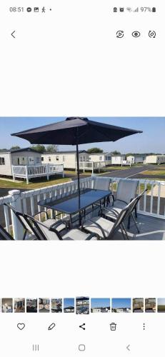 a table and chairs under an umbrella on a deck at 23 the pastures in Tattershall