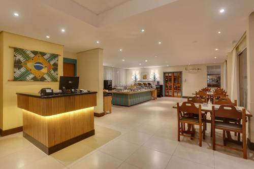 a restaurant with a bar and a dining room at Costa Norte Ponta das Canas Hotel in Florianópolis