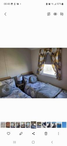 Duas camas num pequeno quarto com uma janela em 23 the pastures em Tattershall
