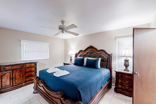 a bedroom with a blue bed and a ceiling fan at Canal Carnival in Sebring