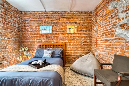 - une chambre avec un lit et un mur en briques dans l'établissement Casa Lumo in Roma Norte by Tasman, à Mexico
