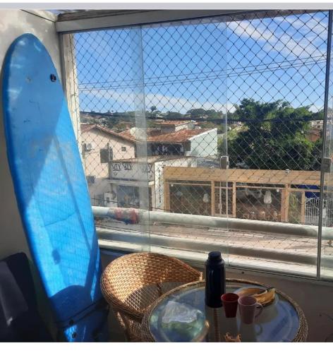 una mesa con tabla de surf frente a una ventana en Loft em Búzios en Búzios
