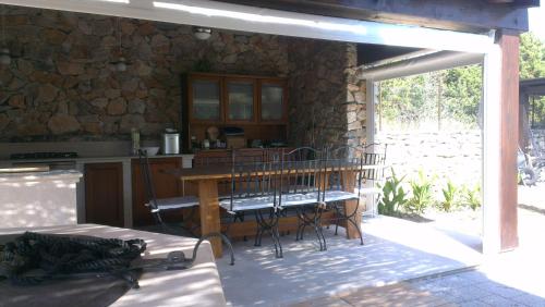 eine Terrasse mit einem Tisch, Stühlen und einer Steinmauer in der Unterkunft Apartment Tasha in Ist